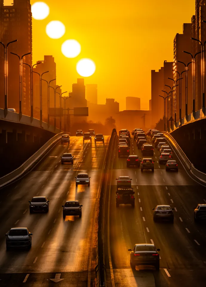 A sequence of suns above city traffic at sunset