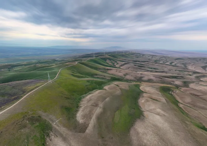 Aerial view of eroded ridges and green hills
