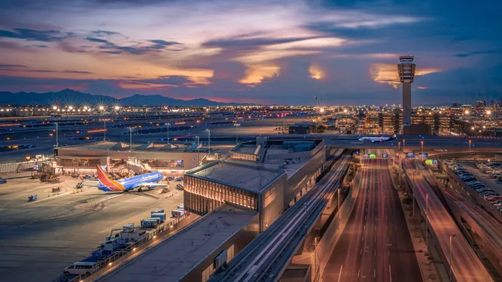 Airport runways, aircraft, and a control tower under a pastel evening sky